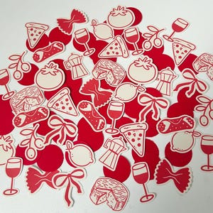 Pu&ograve; includere: Una collezione di adesivi rossi e color crema a tema italiano. Gli adesivi presentano illustrazioni di fette di pizza, calici di vino, pomodori, limoni, pasta, caffettiere e olive. Gli adesivi sono sparsi su una superficie bianca.