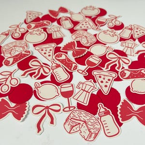 Pu&ograve; includere: Una collezione di ritagli di carta rossi e color crema con illustrazioni di cibo e bevande italiani. I disegni includono fette di pizza, calici, pomodori, fiocchi di pasta, caffettiere e biberon.