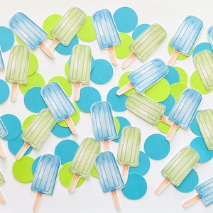 May include: A collection of paper die-cut shapes featuring light blue and lime green popsicle illustrations with wooden sticks, interspersed with solid blue and lime green paper circles, creating a colorful and festive confetti arrangement.