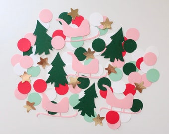 May include: Assortment of Christmas confetti featuring pink, green, red, and white circles, gold stars, pink sleighs, and green Christmas trees.