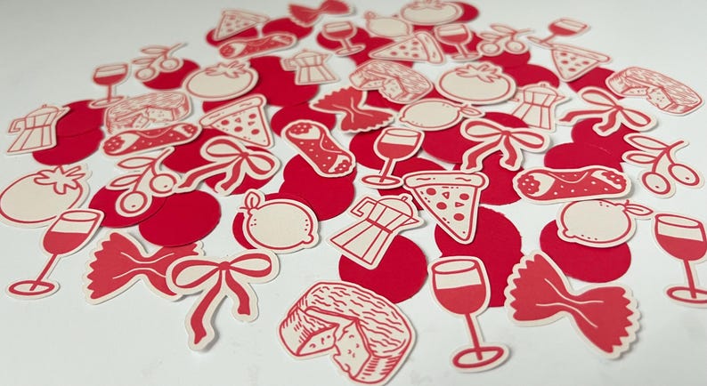 Pu&ograve; includere: Una collezione di ritagli di carta rossi e bianchi a tema italiano. I ritagli includono fette di pizza, calici, pomodori, farfalle, limoni, ciliegie, caffettiere e formaggio. I ritagli sono sparsi su una superficie bianca.