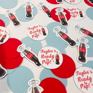 May include: Confetti featuring red, light blue, and white circles. The confetti includes cutouts of vintage cola bottles and circles with the text "Taylor's Ready to Pop!" in red script.