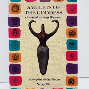 May include: A book titled AMULETS OF THE GODDESS Oracle of Ancient Wisdom by Nancy Blair. The cover features a dark brown stylized female figure in the center, surrounded by a border of colorful squares containing various circular symbols.