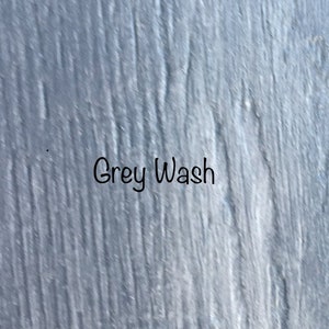 May include: A close-up of a textured, gray painted surface with the words "Grey Wash" written in black.