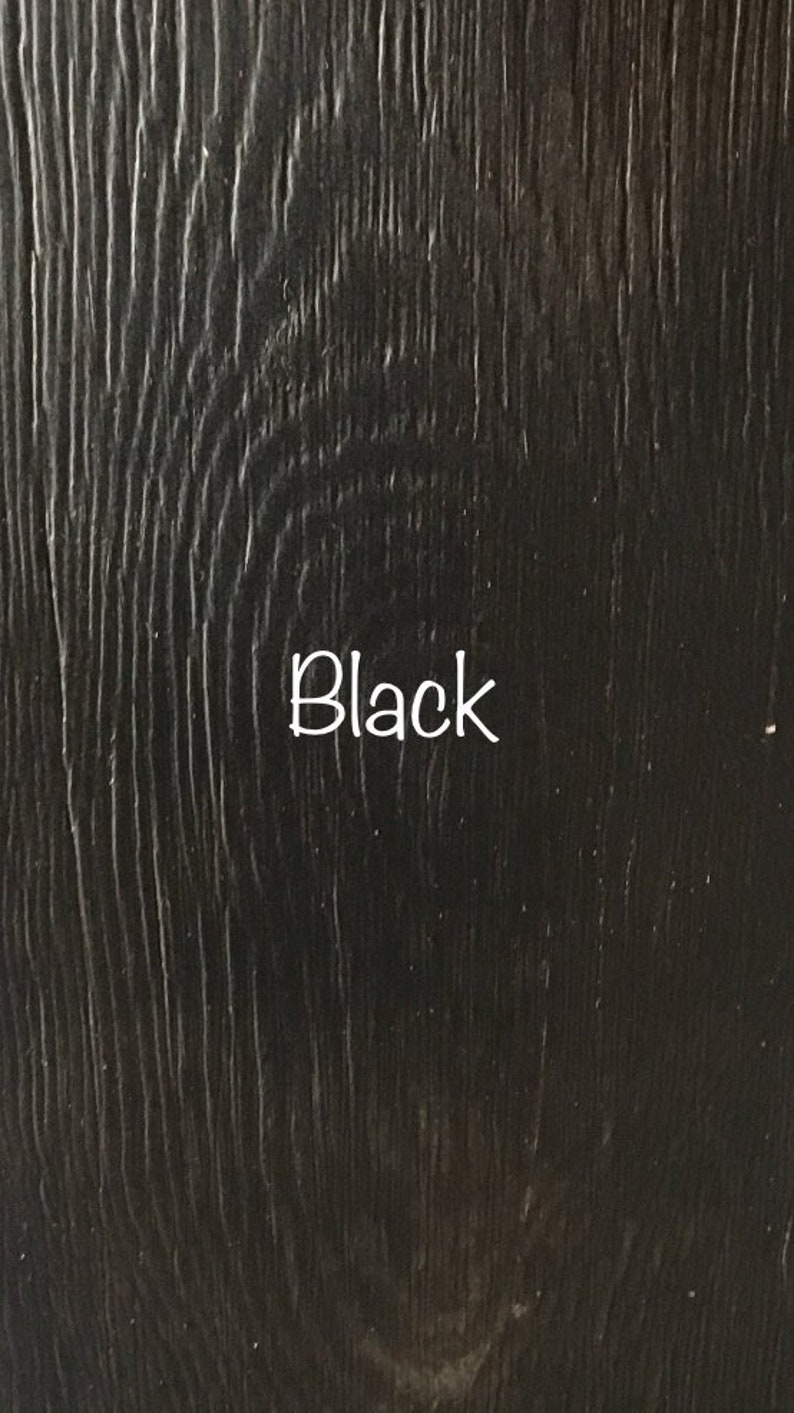 May include: Close-up of a black wood grain surface. The word "Black" is written in white text on the surface.
