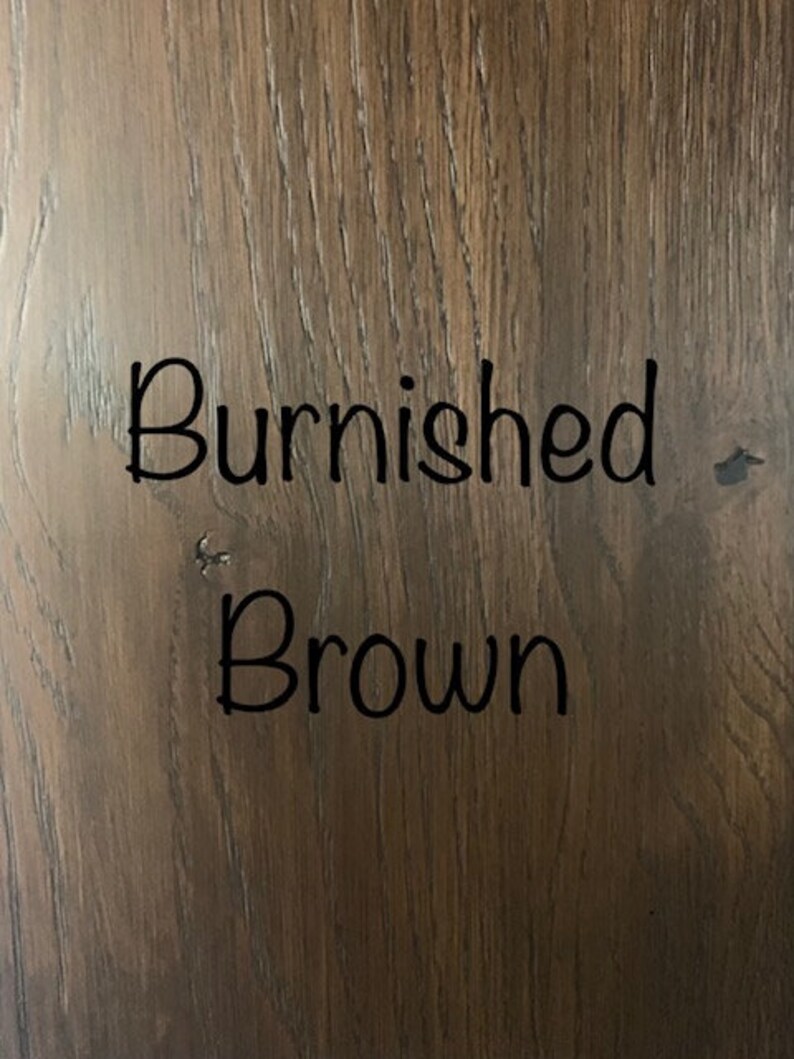 May include: A close-up of a wood grain surface with the text "Burnished Brown" written in black.