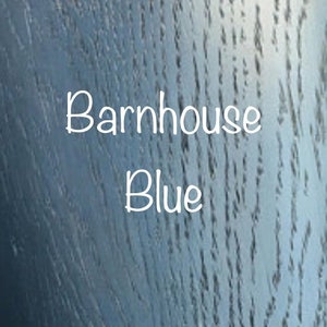 May include: A close-up of a wood grain surface painted in a blue color. The text "Barnhouse Blue" is written in white on the surface.