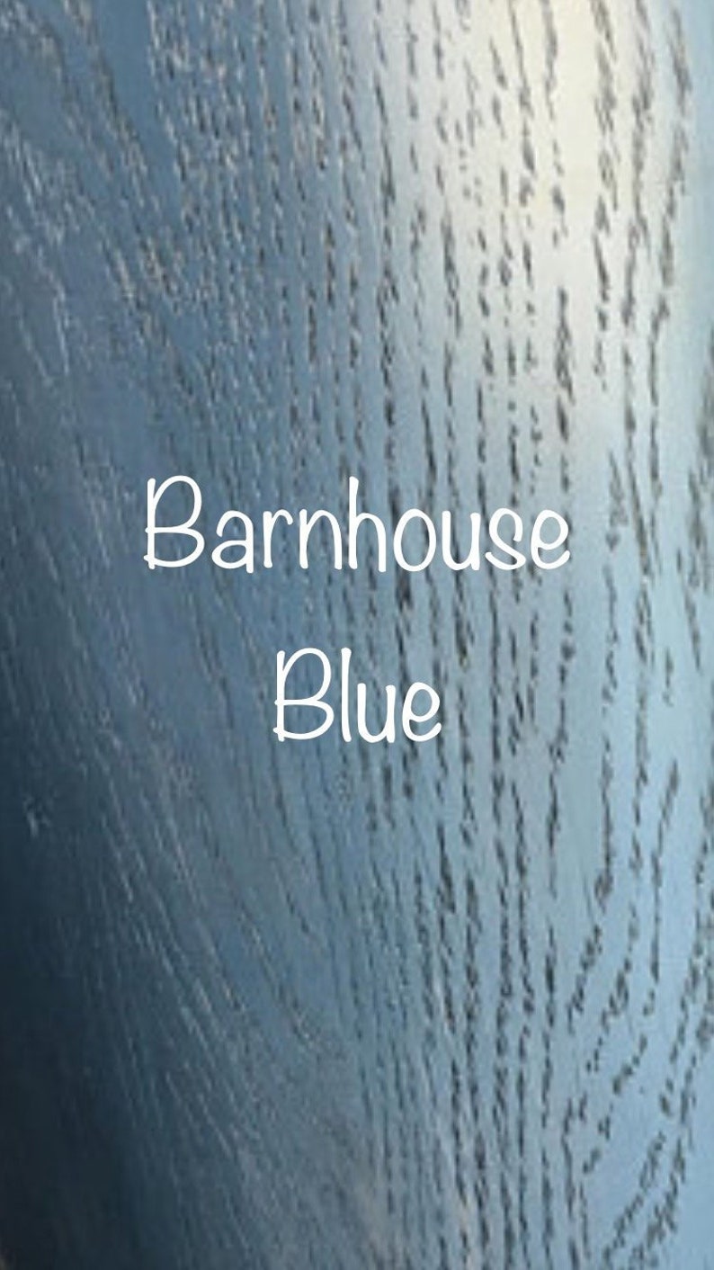 May include: A close-up of a wood grain surface painted in a blue color. The text "Barnhouse Blue" is written in white on the surface.