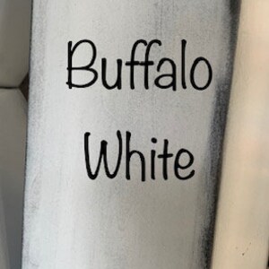 May include: A close-up of a white painted surface with the words "Buffalo White" written in black.