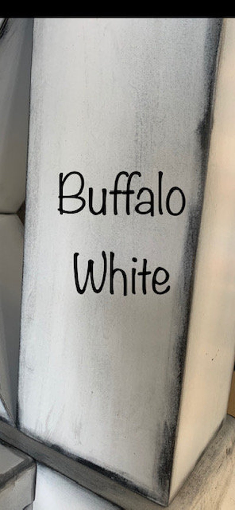 May include: A close-up of a white painted surface with the words "Buffalo White" written in black.