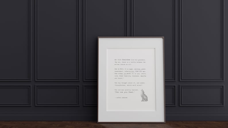 May include: Framed print with a quote from an old Cherokee, featuring a wolf illustration. The print has a white background with black text and a brown frame. The print is leaning against a dark gray wall.