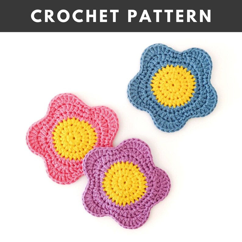 May include: Three handmade crochet flower coasters in pink, blue, and purple, each with a yellow centre. The text "CROCHET PATTERN" is at the top of the image.