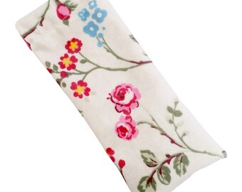 May include: A white eye mask with a floral pattern featuring pink, red, and blue flowers on a white background.