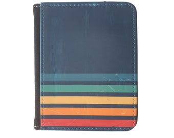 Pode incluir: Uma carteira de couro azul com um design de listras multicoloridas. As listras são vermelhas, laranja, amarelas, verdes e azuis.