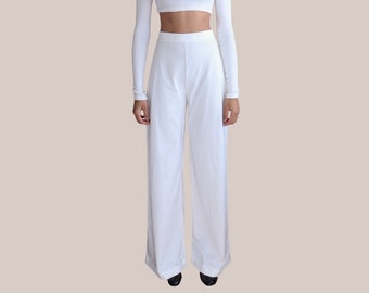 May include: A white long-sleeved crop top and matching wide-leg pants. The top has a round neckline and the pants have a high waist.