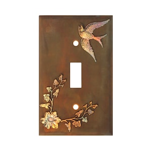May include: A light switch cover with a rustic brown finish features a gold and iridescent floral design and a flying bird.