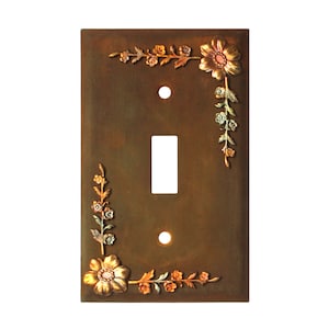 May include: A decorative light switch cover with a rustic brown background and a floral design in shades of green, orange, and gold.
