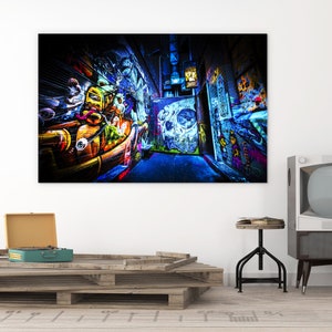 May include: A narrow alleyway with colorful graffiti art on the walls. The walls are covered in a variety of colors, including blue, green, yellow, orange, and red. The graffiti includes abstract designs, letters, and figures. The alleyway is lit by a single light source, creating a dramatic effect.