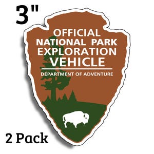 Puede incluir: Una pegatina de 7,6 cm con el texto "OFFICIAL NATIONAL PARK EXPLORATION VEHICLE" y "DEPARTMENT OF ADVENTURE". La pegatina presenta un diseño de punta de flecha marrón con un paisaje verde y un bisonte blanco. También se ven las palabras "2 Pack".