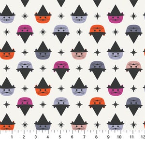 May include: A white fabric with a repeating pattern of black stars and colorful cats wearing witch hats. The cats are orange, pink, and gray.