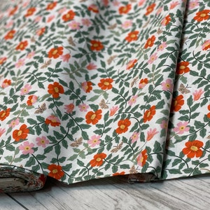 K&ouml;nnte beinhalten: Wei&szlig;er Stoff mit einem sich wiederholenden Muster aus orangefarbenen und rosa Bl&uuml;ten, gr&uuml;nen Bl&auml;ttern und braunen Schmetterlingen.
