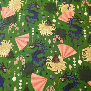 May include: Green fabric with a repeating pattern of blue dragons, pink fans, yellow flowers, and white and green accents.