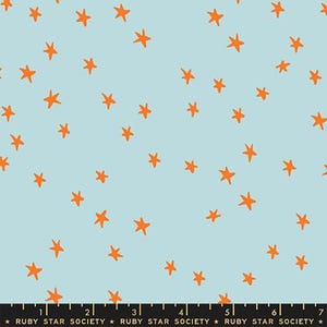May include: Light blue fabric with a scattered pattern of orange stars. The stars are irregularly shaped and evenly distributed across the surface. The fabric has a soft, matte finish, suitable for various craft projects.