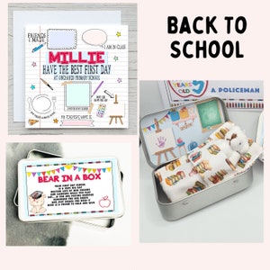 Op de afbeelding: Een verzameling items met het thema terug naar school. Bevat een gepersonaliseerde kaart met de tekst "Millie Have the Best First Day", een blikje met een beer in een doos en een blikje met een beer in bed.