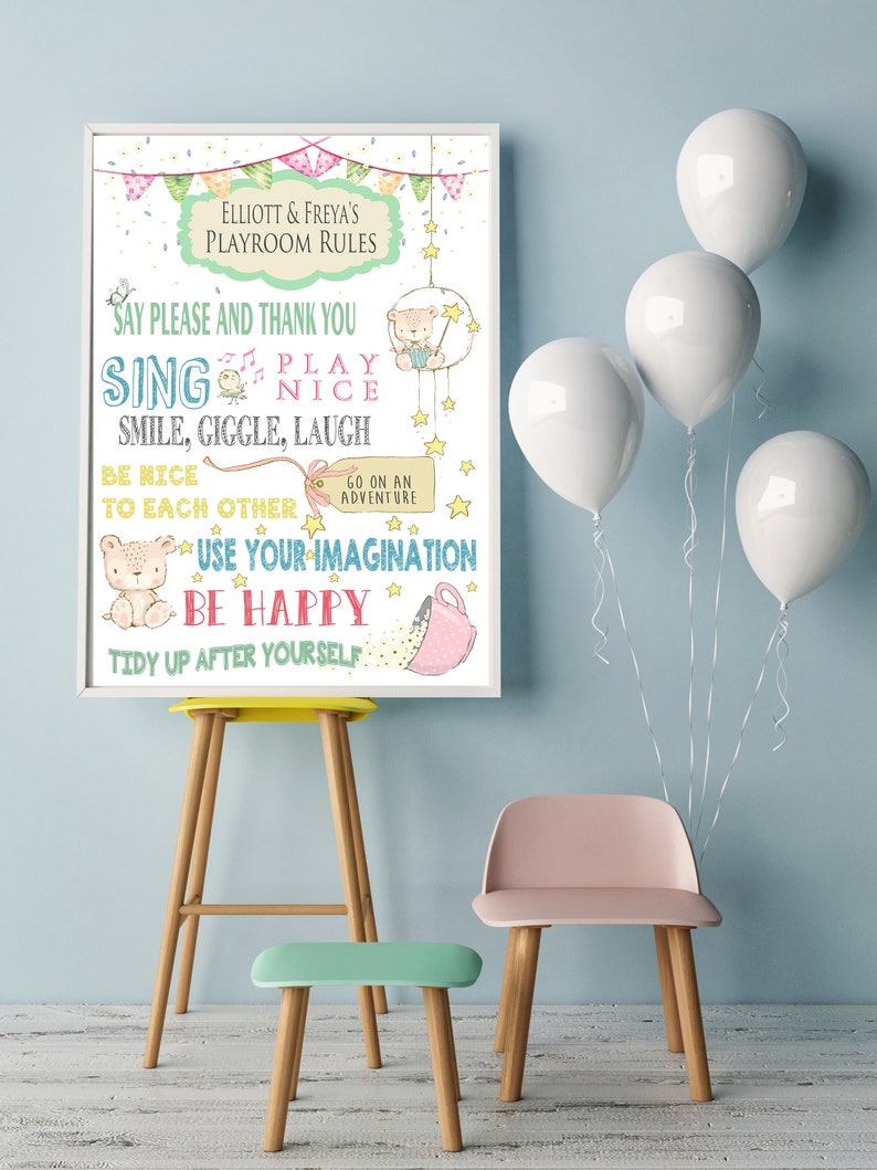 Op de afbeelding: Een ingelijste poster met de tekst "Elliott & Freya's Playroom Rules". De poster bevat illustraties van een beer, sterren en een theekopje. De tekst bevat zinnen als "Zeg alsjeblieft en bedankt", "Zing" en "Wees blij".