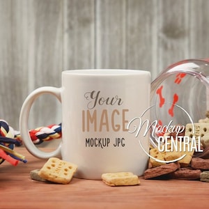 Puede incluir: Taza de cer&aacute;mica blanca con asa, con el texto "Your Image" y "Mockup JPG". La taza est&aacute; sobre una superficie de madera con galletas para perros y un juguete de cuerda.