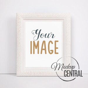 Op de afbeelding: Witte fotolijst met een versierd ontwerp. De lijst staat op een wit oppervlak. De tekst "Your IMAGE" staat in de lijst.