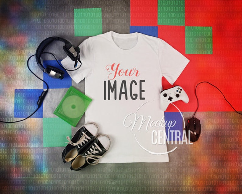 May include: A white t-shirt with the text "Your IMAGE" printed on the front. The t-shirt is lying flat on a colourful background with a pair of headphones, a game controller, a game disc, and a pair of trainers.