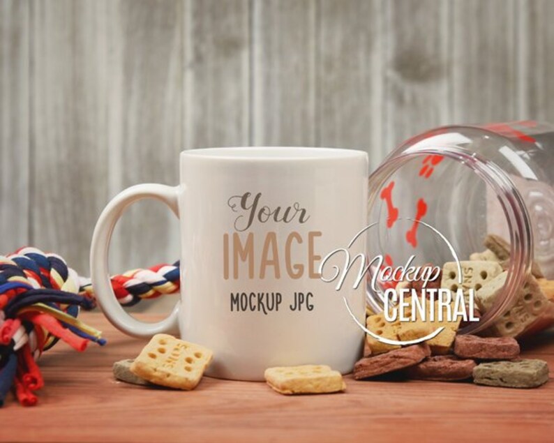 Puede incluir: Taza de cer&aacute;mica blanca con asa, con el texto "Your Image" y "Mockup JPG". La taza est&aacute; sobre una superficie de madera con galletas para perros y un juguete de cuerda.