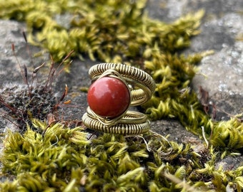 Accessorio per dreadlock in ottone dorato, realizzato a mano, con gemma di diaspro rosso.