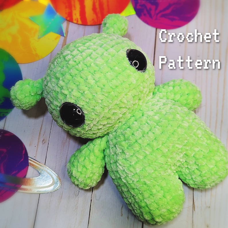 May include: Green crocheted alien plush toy with black eyes. Crochet pattern.