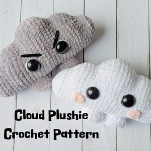 May include: Two handmade crochet cloud plushies. One is gray with a black angry face, and the other is white with a happy face and pink cheeks. The text "Cloud Plushie Crochet Pattern" is at the bottom.