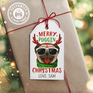 May include: A white gift tag with a cartoon pug wearing sunglasses and reindeer antlers. The text on the tag reads "Merry Puggin' Christmas Love, Sam".