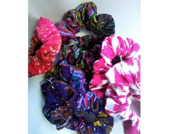 May include: A set of six colorful fabric hair scrunchies with different patterns. The scrunchies are made of soft, stretchy fabric and are perfect for holding hair in place.