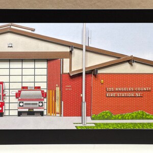 May include: A paper model of a Los Angeles County Fire Station 51, with two red fire trucks parked inside the bay. The building is made of red brick with a brown roof and a sign that reads "Los Angeles County Fire Station 51".