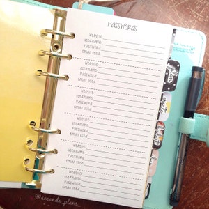 May include: A white page with a gold binder and a blue binder. The white page has the word "PASSWORDS" written at the top. The page is divided into sections with the headings "website", "username", "Password", and "email used".