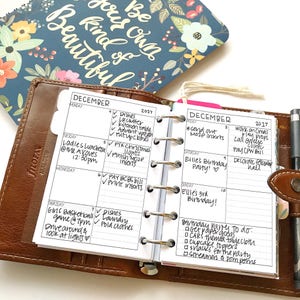 May include: A close-up of a brown leather planner open to the December 2017 pages. The planner has a weekly layout with a list of tasks and appointments for each day. The planner is decorated with a heart and a checkmark.