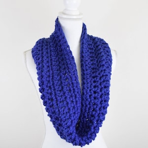 May include: A royal blue crocheted infinity scarf. The scarf is made with a chunky yarn and has a simple, yet elegant design.