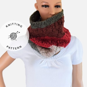 Puede incluir: Un cuello de punto en tonos rojos, marrones, beige y verdes. El cuello está puesto por una persona con una camisa blanca.