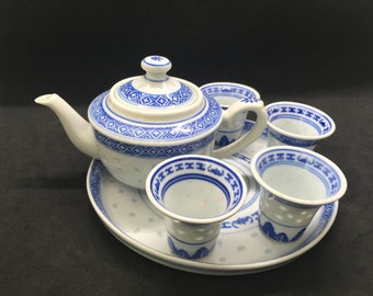 May include: A blue and white porcelain tea set with a teapot, four cups, and a saucer. The set features a traditional Chinese design with blue and white floral patterns.
