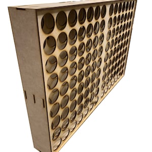 May include: A wooden paint pot holder with 72 round holes for storing paint pots. The holder is made of light brown wood and has a rectangular shape.