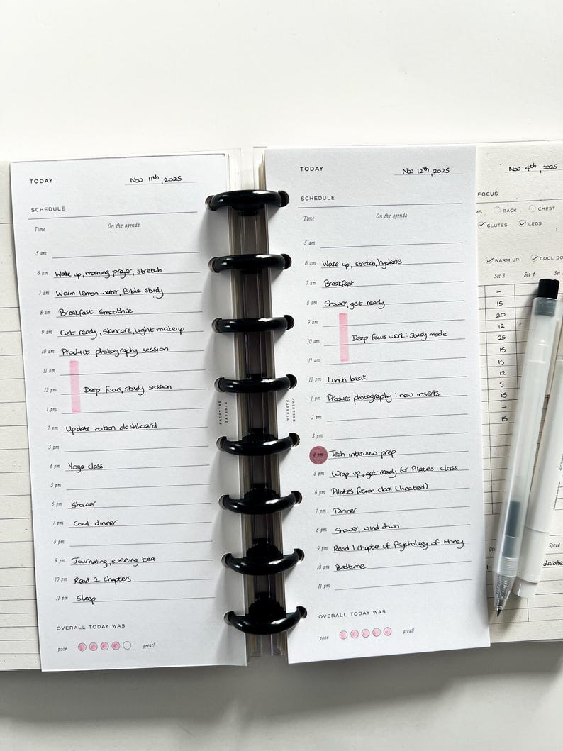 Op de afbeelding: Een planner met een zwarte binding, opengeklapt op twee pagina's met dagschema's. De linkerpagina is gedateerd 11 november 2025, de rechterpagina 12 november 2025. Elke pagina heeft een gedetailleerd schema.