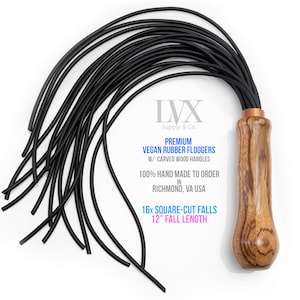 May include: A black vegan rubber flogger with a carved wooden handle. The flogger has 16 square-cut falls and a 12-inch fall length. The text on the handle reads "LVX Supply & Co. Premium Vegan Rubber Floggers W/ Carved Wood Handles 100% Hand Made To Order In Richmond, VA USA 16x Square-Cut Falls 12" Fall Length".