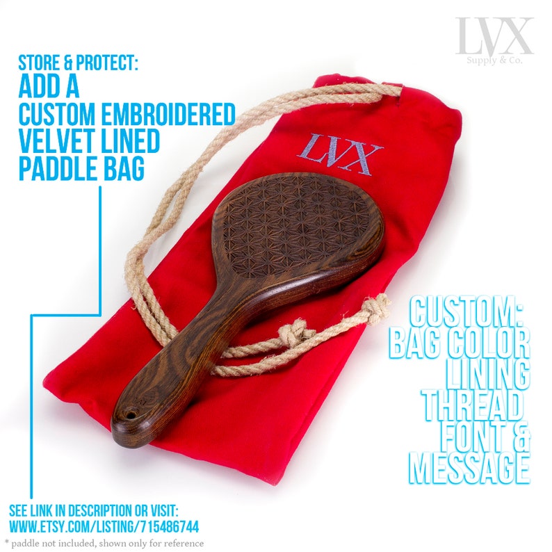 May include: A red velvet lined bag with a drawstring closure and a wooden paddle with a geometric pattern. The bag has the text "LVX" embroidered on it. The text "STORE & PROTECT: ADD A CUSTOM EMBROIDERED VELVET LINED PADDLE BAG" is in the top left corner of the image. The text "CUSTOM: BAG COLOR LINING THREAD FONT & MESSAGE" is in the bottom right corner of the image.