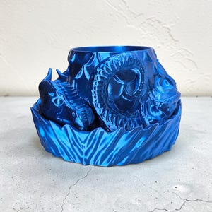 Pode incluir: Um vaso azul royal impresso em 3D com um design de drag&atilde;o. O vaso apresenta uma cabe&ccedil;a e um corpo de drag&atilde;o detalhados, com escamas texturizadas e uma base decorativa. O texto "Silk Royal Blue" est&aacute; na parte inferior.