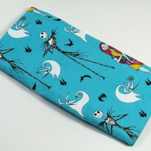 May include: A turquoise fabric with a repeating pattern of Jack Skellington and Sally from The Nightmare Before Christmas. The fabric is ideal for crafting projects such as cushions, bags, and quilts.